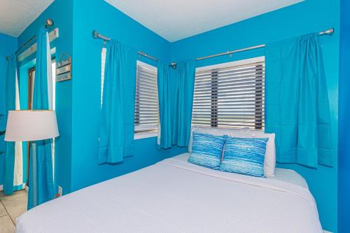 ein blaues Schlafzimmer mit einem Bett und einem Fenster in der Unterkunft The Palace 705 in Myrtle Beach