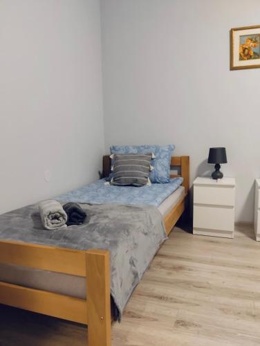 a bedroom with a bed with blue sheets and a wooden floor at Apartman Katarina Bački Monoštor in Bački Monoštor