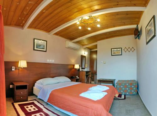 een slaapkamer met een bed en een houten plafond bij TARLAS ROOMS in Mytilini