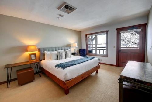 a bedroom with a bed and a table and a window at Casia Lodge and Ranch in Twisp