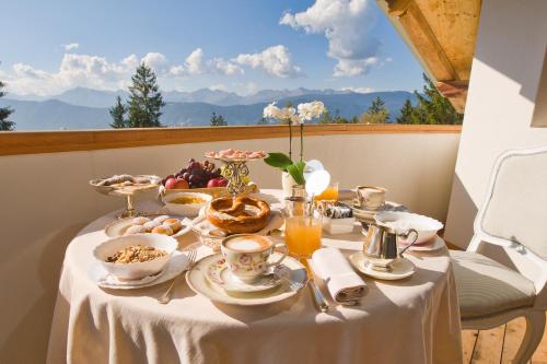 een tafel met eten erop met uitzicht op de bergen bij Villa Orso Grigio in Ronzone
