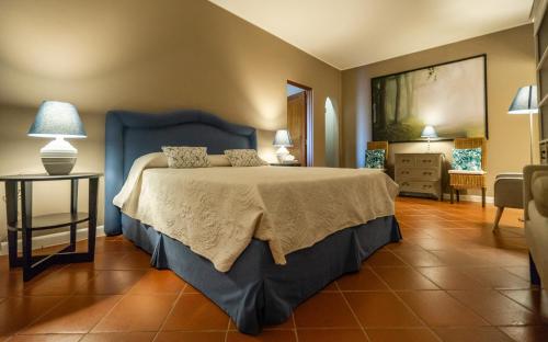 a bedroom with a large bed with a blue head board at Relais La Martina in Pietraviva