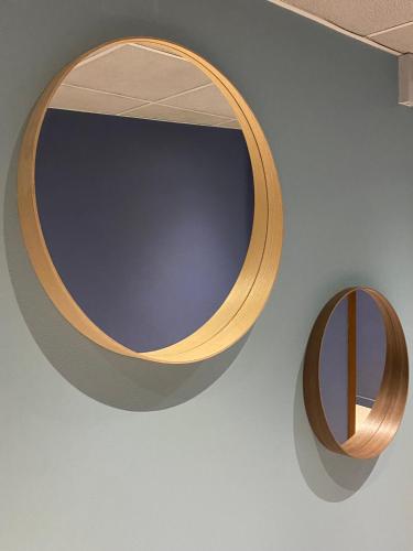 a wooden mirror hanging on a wall next to a wall at Hôtel Juantorena in Saint-Étienne-de-Baïgorry