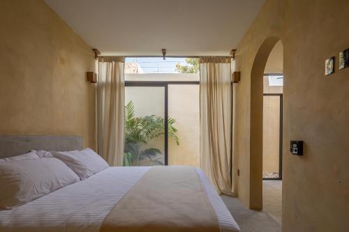 a bedroom with a bed and a large window at Casa Kame in Puerto Escondido