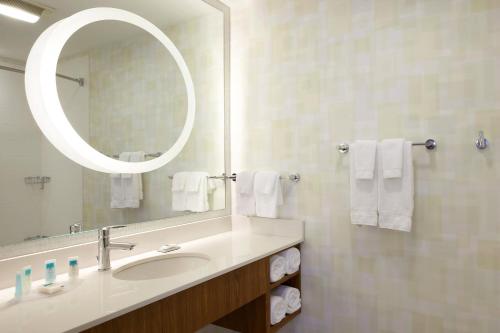 a bathroom with a sink and a mirror and towels at SpringHill Suites by Marriott Chicago Waukegan/Gurnee in Waukegan