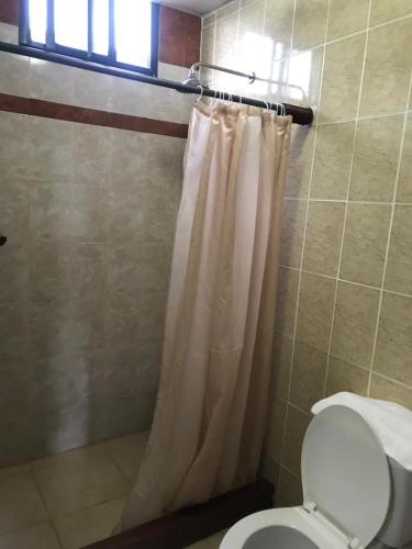 a bathroom with a shower curtain and a toilet at Residencial Santa Catalina Pedasi in Pedasí Town