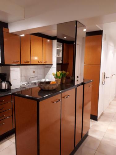 a kitchen with brown cabinets and a bowl of fruit on the counter at Shamrock Oostduinkerke in Oostduinkerke