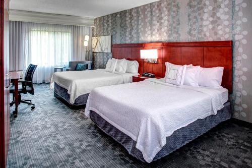 a hotel room with two beds and a desk at Courtyard Richmond North/Glen Allen in Richmond