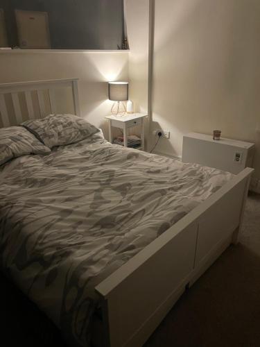 1 cama grande en un dormitorio con una lámpara sobre una mesa en Cable Yard, en Liverpool