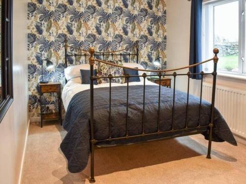 una camera con un letto in una stanza con carta da parati di Cremlyn Lodge a Beaumaris