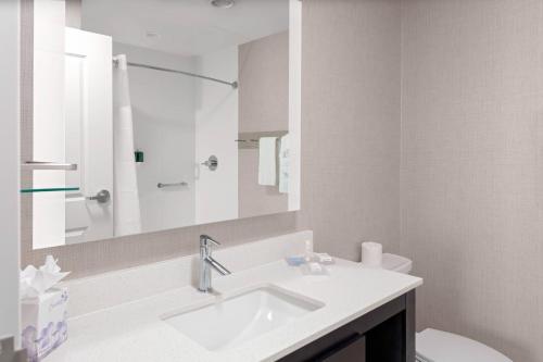 a white bathroom with a sink and a mirror at Residence Inn by Marriott Phoenix Mesa East in Ciela Grande Mobile Home Park