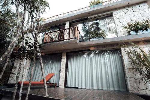 a house with a deck and a balcony at Kaaba Luum Jungle Villas in Chemuyil