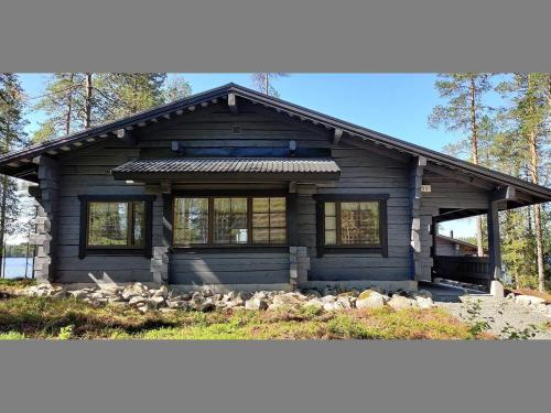 eine Blockhütte im Wald mit einem großen Fenster in der Unterkunft Holiday Home Kiviniemi by Interhome in Siikakämä