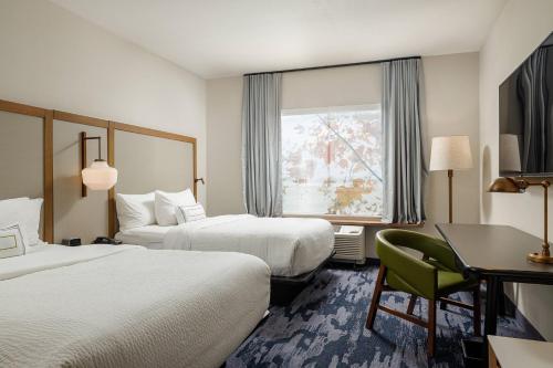 a hotel room with two beds and a desk and a window at Fairfield Inn & Suites by Marriott Salina in Salina