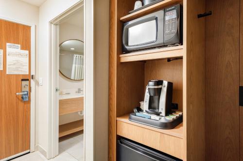 a room with a microwave and a television on a cabinet at Fairfield Inn & Suites by Marriott Salina in Salina