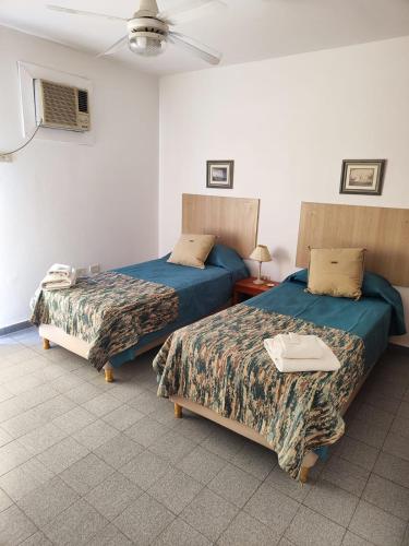 1 dormitorio con 2 camas y ventilador de techo en Departamento Del Estero en La Rioja
