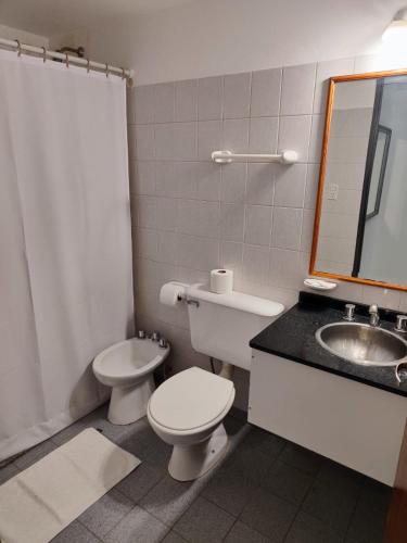 y baño con aseo, lavabo y espejo. en Departamento Del Estero en La Rioja