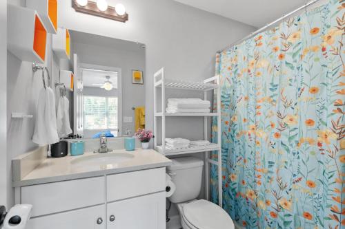 a bathroom with a toilet and a shower curtain at Beautiful 3-suite home w/ patio dining, big yard in Tallahassee