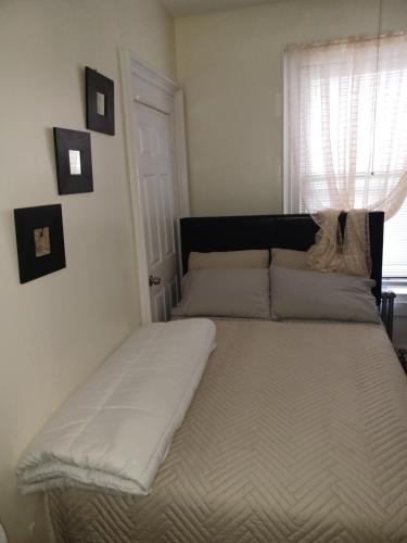 1 cama grande en un dormitorio con ventana en The Heiress Hubb, en Brooklyn