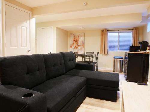 un soggiorno con divano nero e tavolo di Private Basement, Bath, Living Area In Morrison a Morrison
