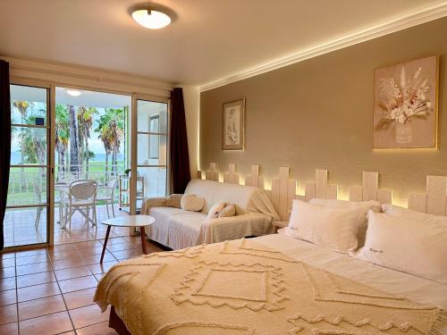 a bedroom with a bed and a living room at Curaçao 13 studio vue mer proche plage dans Complexe type Village Vacances in Sainte-Luce