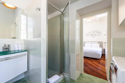 a bathroom with a shower and a toilet and a bed at PALAIS DE MENTON - Elegant apartment with sea view in Menton