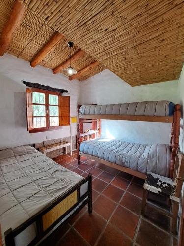 ティルカラにあるCasa en Tilcara con hermosa galeríaの木製の天井が特徴のベッドルーム1室(ベッド2台付)