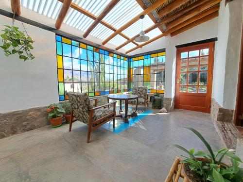 a room with a table and stained glass windows at Casa en Tilcara con hermosa galería in Tilcara