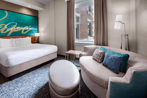 a hotel room with a bed and a couch at Courtyard by Marriott Cape Girardeau Downtown in Cape Girardeau