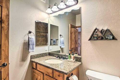 La salle de bains est pourvue d'un lavabo et d'un miroir. dans l'établissement Torreon Vacation Rental with Golf Course View!, à Show Low