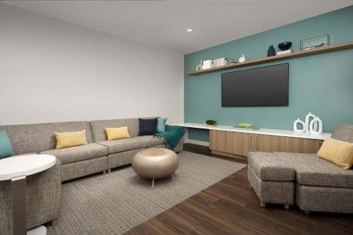 a living room with a couch and a tv at Element Jacksonville Beach in Jacksonville Beach