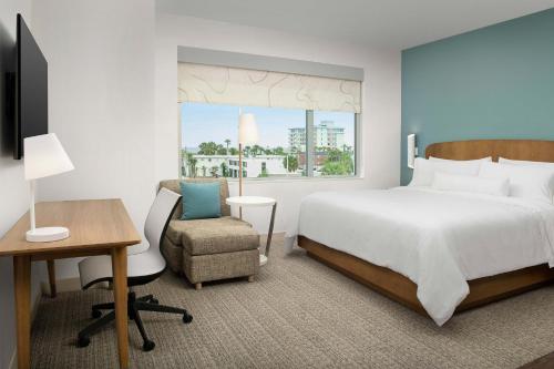 a bedroom with a bed and a desk and a chair at Element Jacksonville Beach in Jacksonville Beach