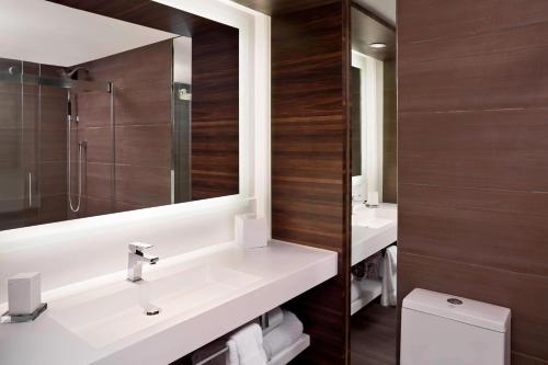 a bathroom with two sinks and a mirror and a toilet at North Charleston Marriott in Charleston