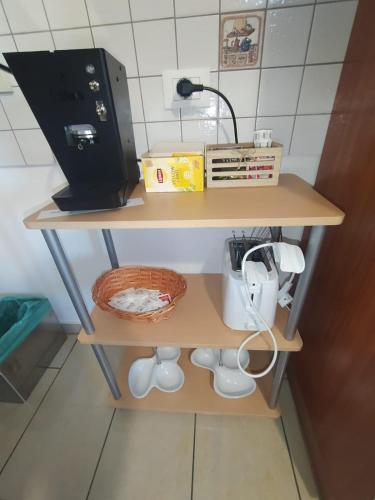 a shelf with a coffee maker and a basket on it at Bed and Breakfast Oasi in Reggio Calabria