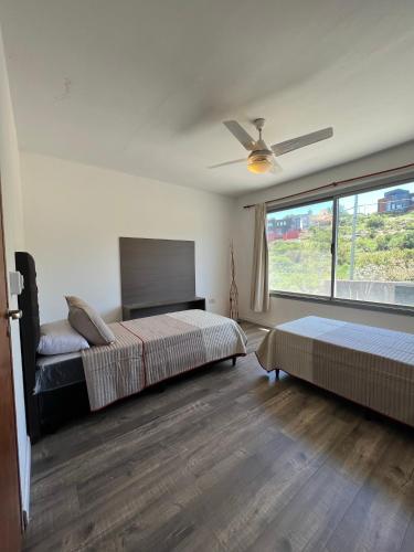 a bedroom with two beds and a ceiling fan at Duplex en plena montaña in Villa Carlos Paz