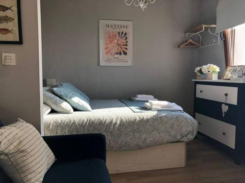 a bedroom with a bed and a chair and a dresser at R2R - La LLastrina - 14A03 in Lastres