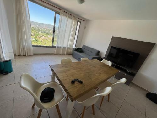 uma sala de estar com uma mesa de madeira e cadeiras em Duplex en plena montaña em Villa Carlos Paz