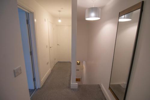 an empty hallway with a mirror and a hallway with a hallway at St Peters Townhouse by Property Promise in Cardiff