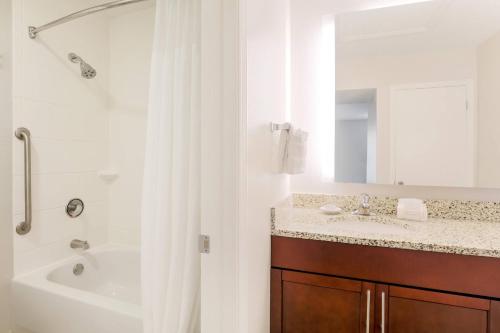 a bathroom with a tub and a sink and a shower at Residence Inn Boca Raton in Boca Raton