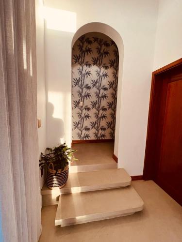 a hallway with an archway with a potted plant at Villa Luasah in Vila Praia Do Bilene
