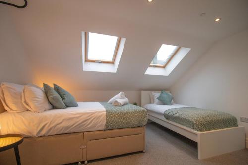 a attic bedroom with two beds with skylights at St Peters Townhouse by Property Promise in Cardiff