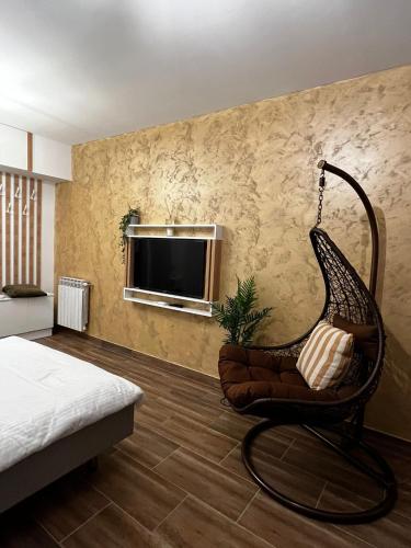 a room with a chair and a television on a wall at One Room Iasi in Iaşi