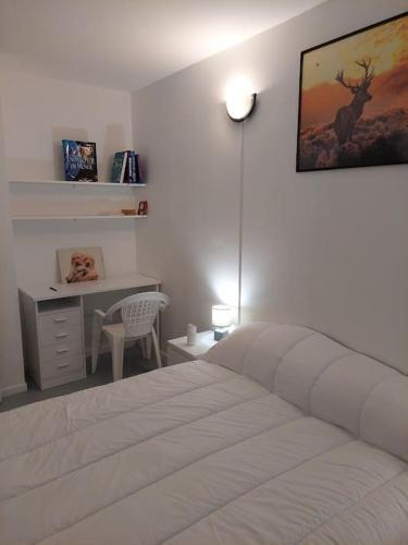- une chambre avec un lit blanc et un bureau dans l'établissement ROSNY15, à Rosny-sous-Bois