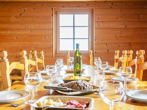 a table with a bottle of wine and wine glasses at Chalet Naulaz by Interhome in Val-d'Illiez