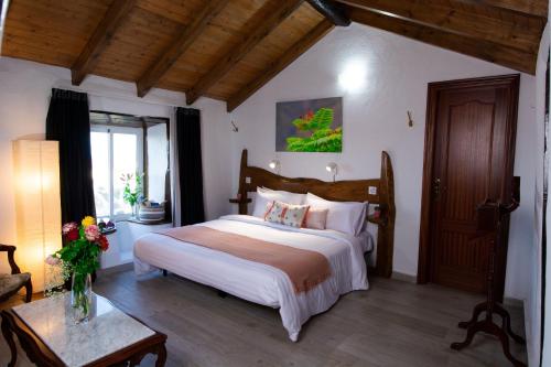 a bedroom with a large bed and a table at Geko Hotels in Los Llanillos