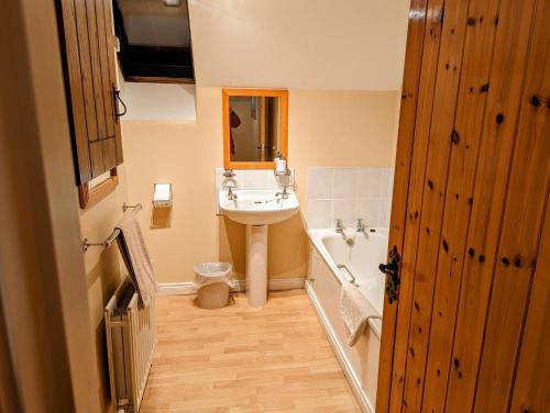 La salle de bains est pourvue d'un lavabo, d'une baignoire et de toilettes. dans l'établissement Millers Close Holiday Cottages, à Newcastle
