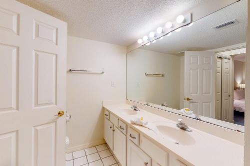 a bathroom with a sink and a large mirror at Islander E 2007 in Fort Walton Beach