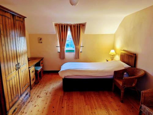 sypialnia z łóżkiem, biurkiem i oknem w obiekcie Millers Close Holiday Cottages w mieście Newcastle