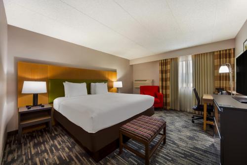 a hotel room with a large bed and a desk at Wingate by Wyndham Lincoln Airport East I-80 in Lincoln