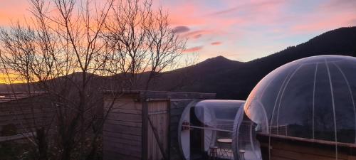 two domes on a house with a sunset in the background at La Bulle d'Ardèche in La Chanal